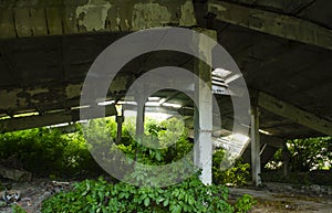 Idustrial interior at the old an abandoned hangar that is overgrown with grass and will soon fall, standing only on a