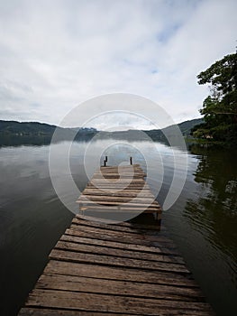 Idyllic Amazon rainforest jungle river lake landscape with broken damaged wooden jetty dock pier in Peru South America