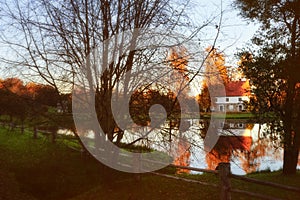 Idyllic autumn landscape with a cottage surrounding by golden trees and beautiful lake