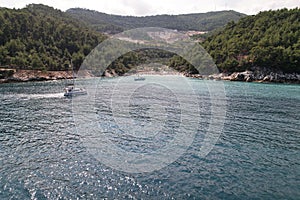 Idyllic bay with yachts and forested mountains in the background