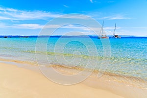 Idyllic beach and blue seaA view of idyllic Grande Sperone beach with crystal clear azure sea water and catamaran boats in