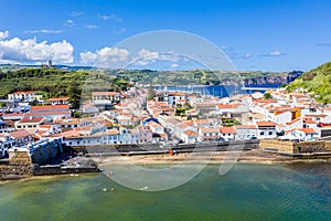 Idyllic beach Praia and azure bay Baia do Porto Pim. Fortifications, walls, gates, red roofs of historical touristic Horta town photo