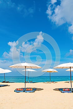 Idyllic beach relaxing concept with white parasols on sand