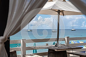 Idyllic beach restaurant with wooden tables and benches and white umbrellas