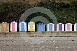 Idyllic beach scene featuring multicolored beach huts lined up in a row.