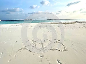 Idyllic beach scene featuring the number 2023 written in the sand, Maldives photo