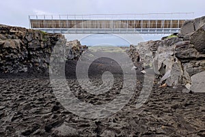 Idyllic beach scene featuring a sandy shoreline and a bridge between continents, Iceland