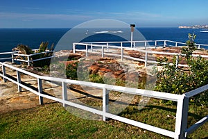 Picturesque and amazing oceanside landscape with grass and white wood fences on cliff by sea in Sydney, Australia