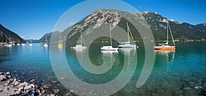 Idyllic blue lake Achensee with moored sailboats