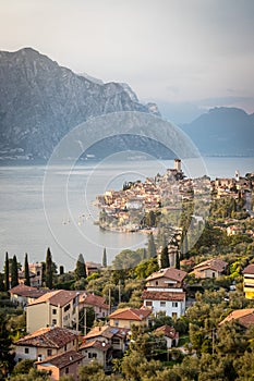 Idyllic coastline in Italy: Blue water and a cute village at lago di garda, Malcesine, sunset