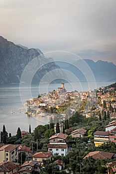 Idyllic coastline in Italy: Blue water and a cute village at lago di garda, Malcesine, sunset