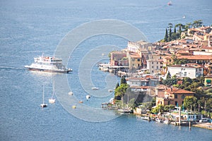 Idyllic coastline scenery in Italy: Blue water and a cute village at lago di garda, Malcesine