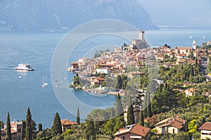 Idyllic coastline scenery in Italy: Blue water and a cute village at lago di garda, Malcesine