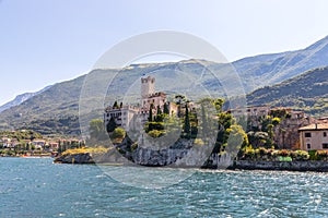 Idyllic coastline scenery in Italy, captured from the water. Blue water and a cute village at lago di garda, Malcesine