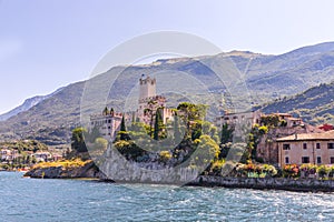 Idyllic coastline scenery in Italy, captured from the water. Blue water and a cute village at lago di garda, Malcesine