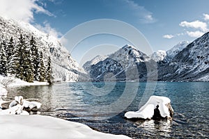 Idyllic cold lake at snow mountain landscape