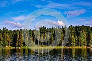 Idyllic countryside landscape view with blue lake and house on the shore. Summer cottage in Finland.