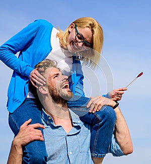 Idyllic date concept. Man carries girlfriend on shoulders, sky background. Woman enjoy perfect romantic date. Couple in