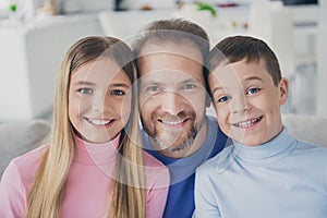 Idyllic family portrait of father with two kids boy girl toothy smile sit couch in house indoors