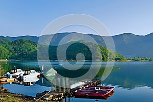 Idyllic lake surrounded by a boat dock on a serene lake with mountains in the background