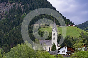 Idyllic landscape in the Alps in springtime with traditional mountain chalet and fresh green mountain pastures with flowers