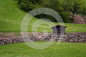 Idyllic landscape in the Alps in springtime with traditional mountain chalet and fresh green mountain pastures with flowers