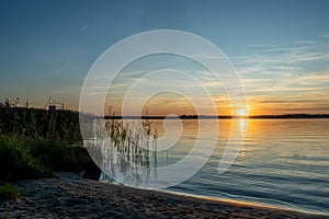 Idyllic landscape. Amazing colorful sunset scene on a quiet lake in summer