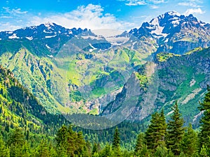 Idyllic landscape with blue sky, green forest and snowcapped mountain top. Svanetia region, Georgia