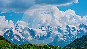 Idyllic landscape with blue sky, green grassland and snowcapped mountain top. Svanetia region, Georgia