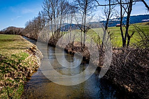 Idyllic landscape. View of river, trees and agriculture field in Switzerland