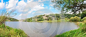 The idyllic mountain tranditional village by river on a beautiful summer afteroon with blossoming trees and grasses