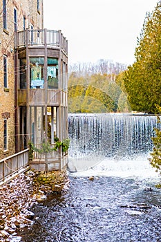 Idyllic natural landscape, waterfall of a river near building with balconies