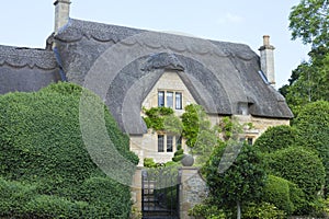 Idyllic old english house with topiary tree garden