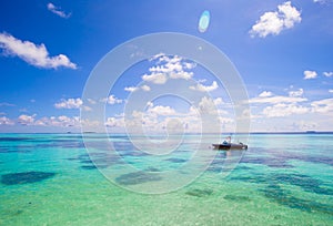 Idyllic perfect turquoise water and boat at exotic island