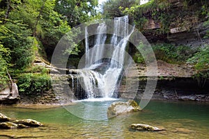 Idyllic rain forest waterfall, stream flowing in the lush green forest.