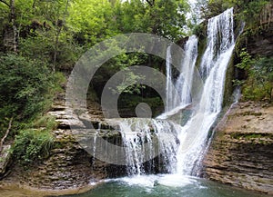 Idyllic rain forest waterfall, stream flowing in the lush green forest.