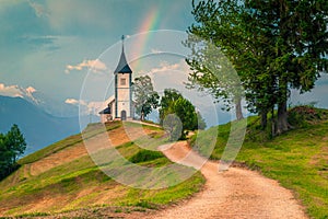 Idyllic rainbow landscape with Saint Primoz church, near Jamnik, Slovenia