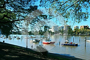 Idyllic river scenery with boats in the middle of the major city Brisbane Australia