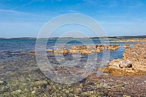 Idyllic rocky beach in tourist destination Medulin, Istria peninsula, Croatia, Europe. Scenic distant view of coastal town