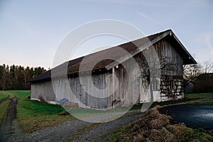 Idyllic scene of a rustic old barn nestled in a tranquil field, with a gravel road