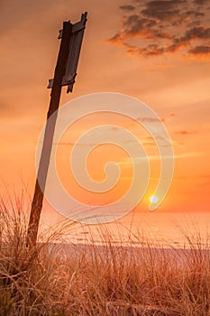 Idyllic shot of sunset by the sea and sign