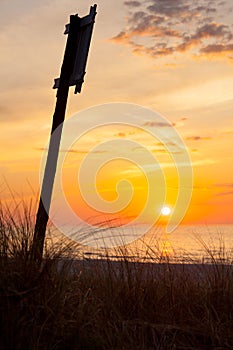 Idyllic shot of sunset by the sea and sign