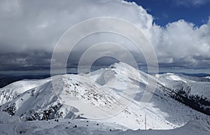 Idylické zasněžené hory v národním parku Nízké Tatry spolu s nejvyššími vrcholy jako Chopok a Ďumbier. Bouře a těžké mraky
