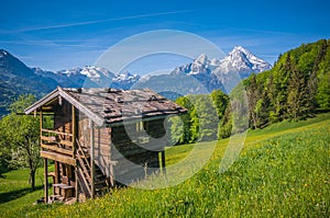 Idyllic springtime landscape in the Alps with traditional mountain cottage