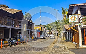Idyllic street houses people cars hotels stores Mazunte Mexico