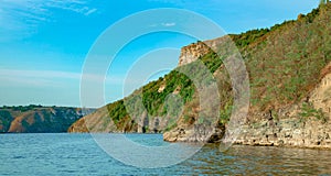 idyllic summer picturesque landscape scenic view of lake water surface and green mountain rocks cliff clear weather day