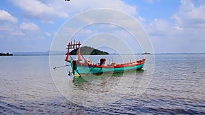 Idyllic summer scene of the ambient motion of a traditional khmer fishing boat lulled in the gentle waves