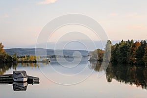 Idyllic sunset over lake in autumn. Sunset boat on lake. Colorful trees reflection in the water. Lake Slnava, Piestany, Slovakia. photo