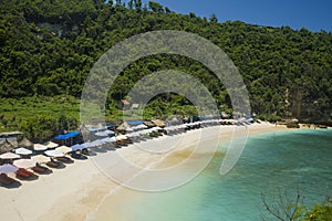 Idyllic tourist destination in Asia - beautiful scenic view of umbrellas in front of turquoise sea water at Atuh beach tropical