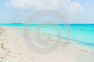 Idyllic tropical beach in Caribbean with white sand, turquoise ocean water and blue sky